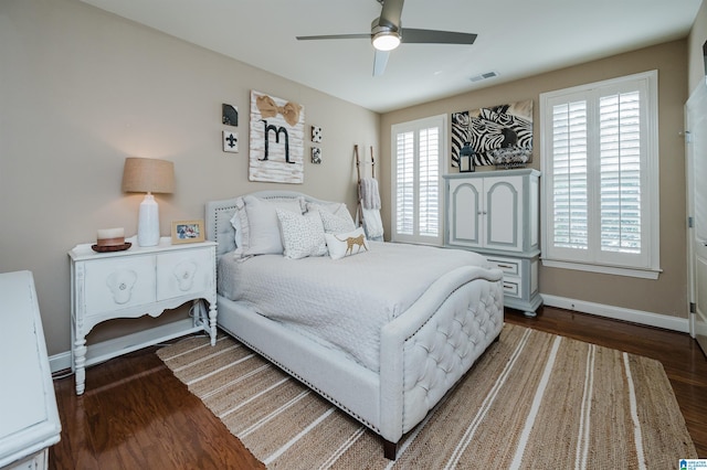 bedroom featuring ceiling fan, dark hardwood / wood-style flooring, and multiple windows