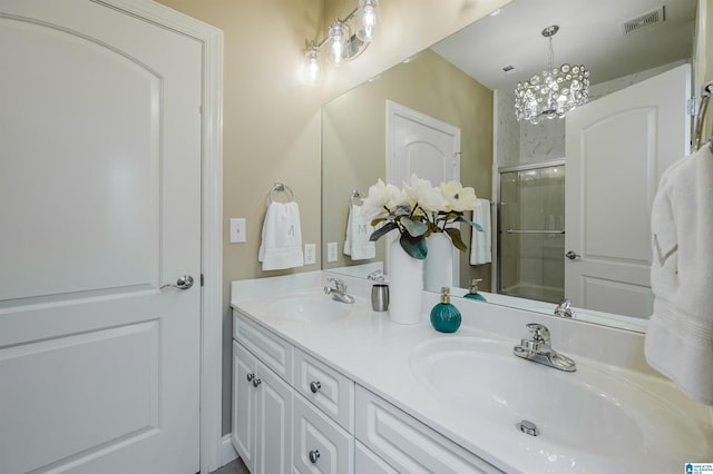 bathroom with a shower with door, vanity, and a chandelier