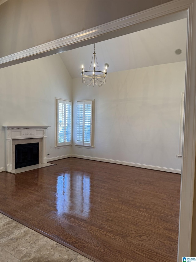 unfurnished living room featuring a chandelier, hardwood / wood-style flooring, and vaulted ceiling