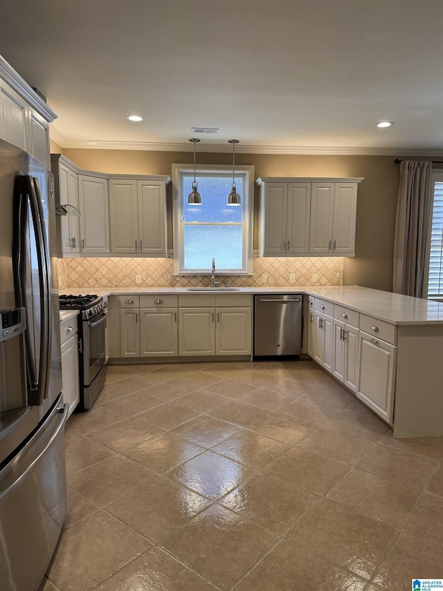 kitchen featuring sink, hanging light fixtures, kitchen peninsula, appliances with stainless steel finishes, and ornamental molding