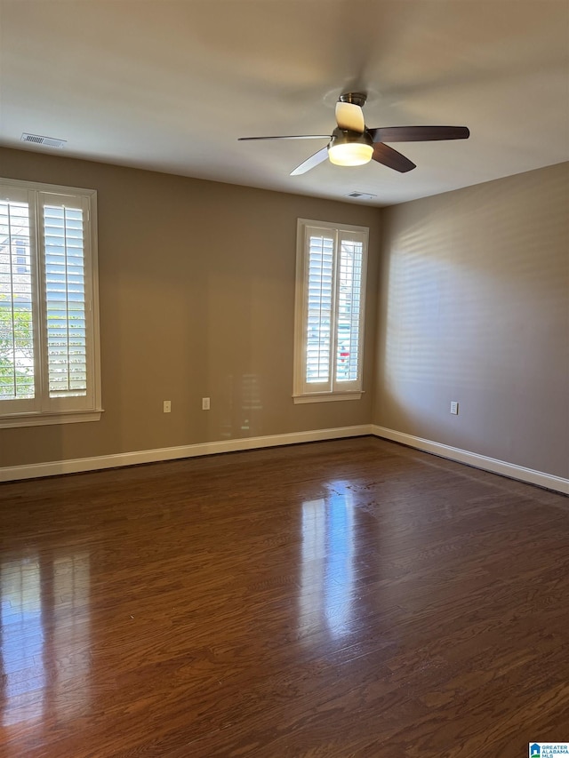 unfurnished room with ceiling fan and dark wood-type flooring