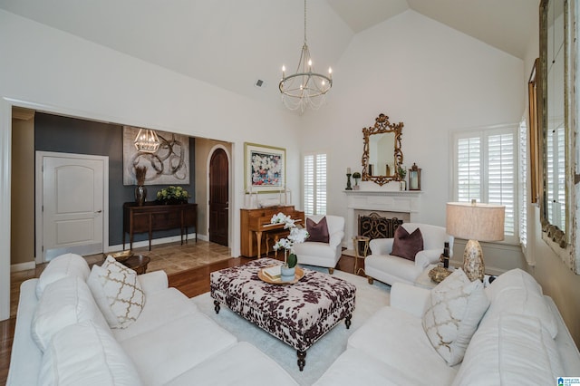 living room with hardwood / wood-style flooring, lofted ceiling, and an inviting chandelier