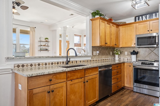 kitchen with light stone countertops, ornamental molding, stainless steel appliances, sink, and dark hardwood / wood-style floors