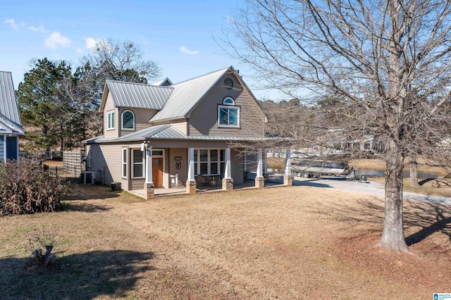 view of front facade featuring central air condition unit, covered porch, and a front yard