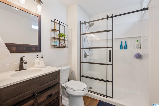 bathroom featuring hardwood / wood-style floors, vanity, an enclosed shower, and toilet