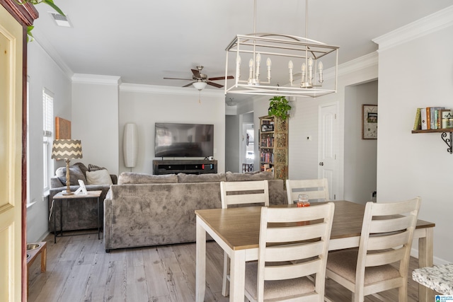 dining room featuring ceiling fan with notable chandelier, hardwood / wood-style flooring, and crown molding