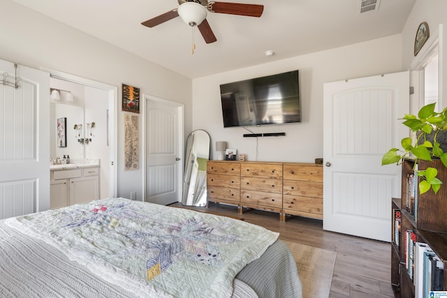 bedroom featuring sink, ensuite bathroom, ceiling fan, and dark hardwood / wood-style floors