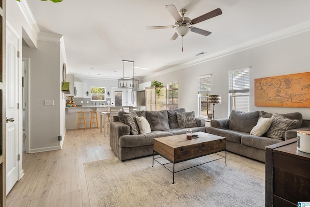 living room with light hardwood / wood-style flooring, ceiling fan, and crown molding