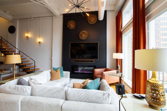 living room featuring beamed ceiling, wood ceiling, and a chandelier