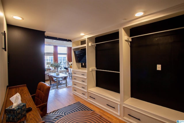 walk in closet with light hardwood / wood-style floors