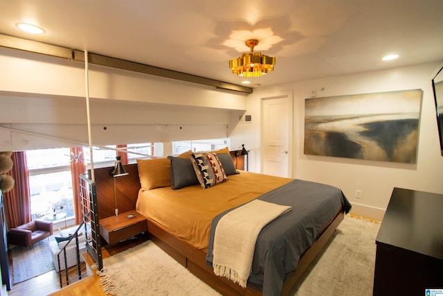 bedroom featuring hardwood / wood-style flooring and an inviting chandelier