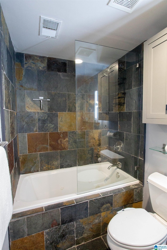 bathroom featuring toilet and tiled shower / bath