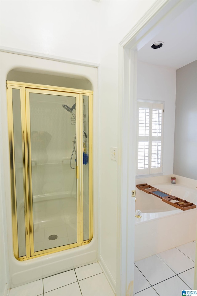 bathroom featuring tile patterned flooring and separate shower and tub