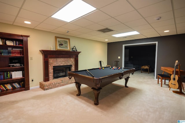 recreation room with a paneled ceiling, pool table, carpet, and a brick fireplace