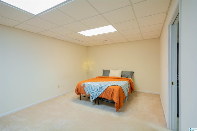 bedroom with light carpet and a paneled ceiling