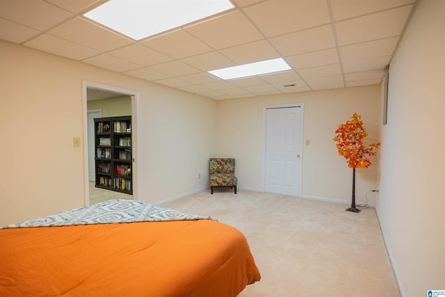 carpeted bedroom featuring a drop ceiling