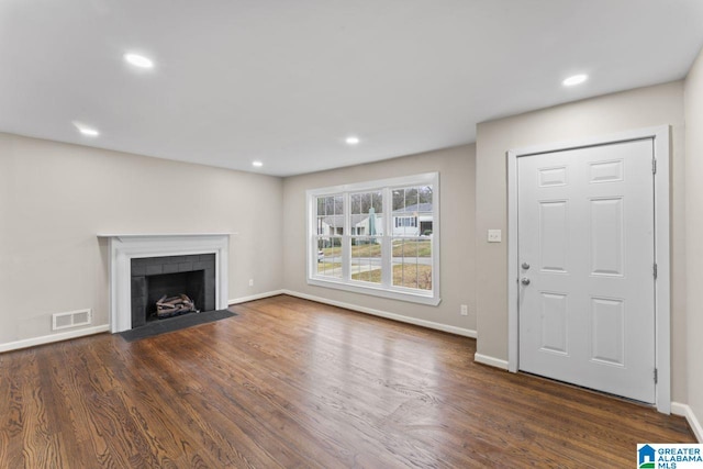 unfurnished living room featuring a fireplace and dark wood-type flooring