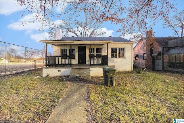 bungalow-style house featuring covered porch and a front lawn