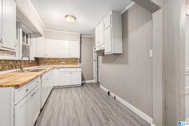 kitchen with white cabinetry, sink, and ornamental molding