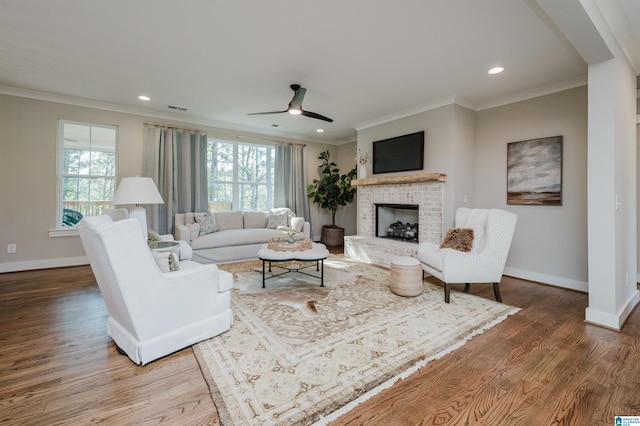 living room featuring a fireplace, ceiling fan, hardwood / wood-style floors, and ornamental molding