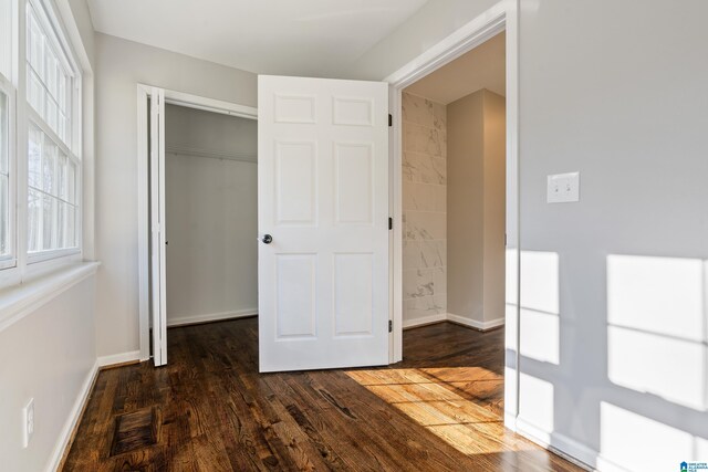 unfurnished bedroom featuring dark hardwood / wood-style flooring and a closet