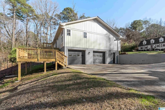 view of side of property featuring a garage and a deck