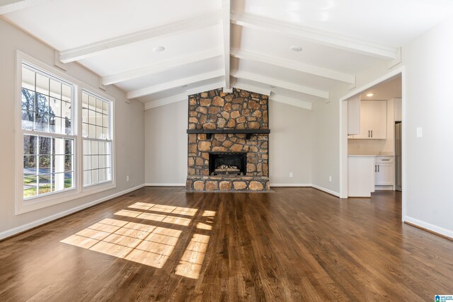 unfurnished living room with vaulted ceiling with beams, a fireplace, and dark wood-type flooring