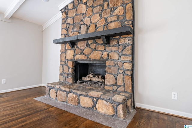 room details with wood-type flooring, a stone fireplace, crown molding, and beam ceiling