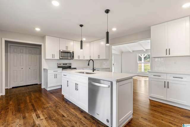 kitchen featuring white cabinetry, sink, stainless steel appliances, dark hardwood / wood-style flooring, and decorative light fixtures