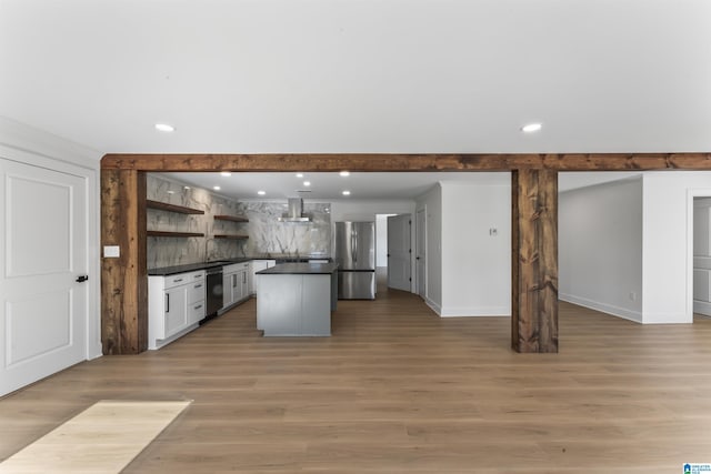 kitchen featuring sink, a center island, ventilation hood, light hardwood / wood-style flooring, and appliances with stainless steel finishes