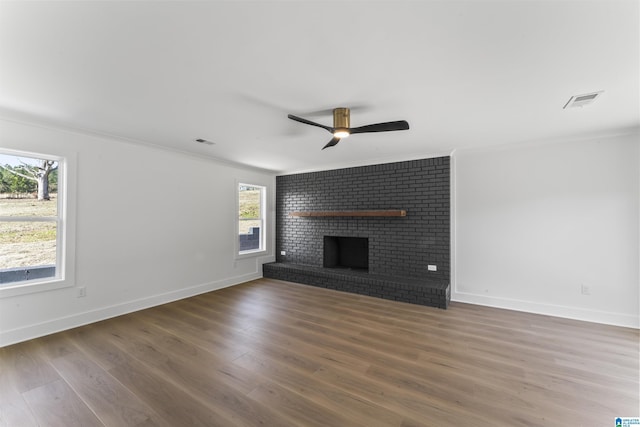 unfurnished living room with crown molding, dark hardwood / wood-style floors, ceiling fan, and a fireplace