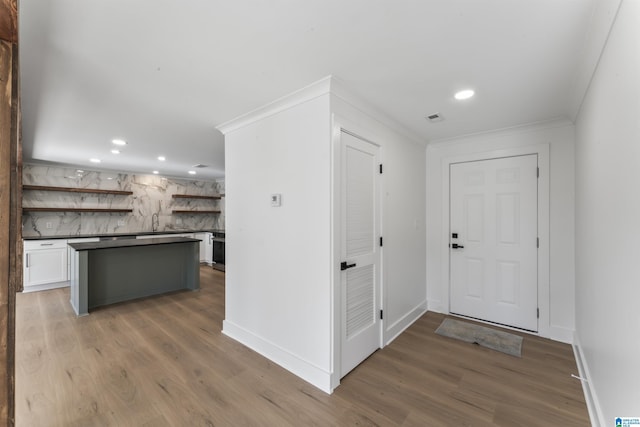 foyer entrance featuring dark wood-type flooring and ornamental molding