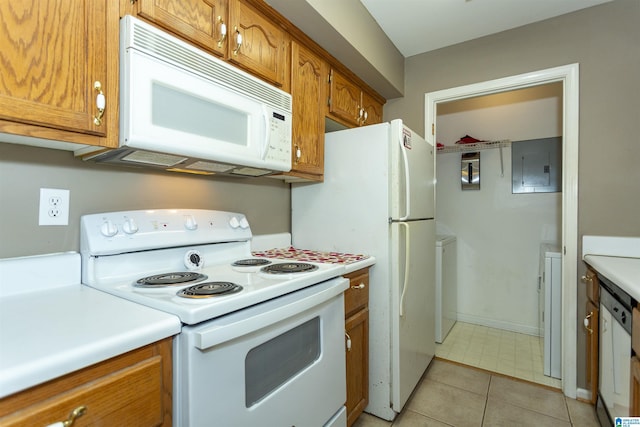 kitchen featuring light tile patterned floors, white appliances, washer / dryer, and electric panel