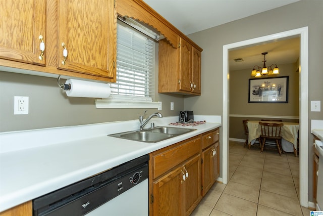 kitchen with sink, hanging light fixtures, an inviting chandelier, dishwashing machine, and light tile patterned flooring