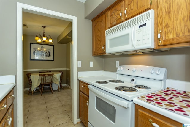 kitchen featuring decorative light fixtures, light tile patterned floors, a chandelier, and white appliances