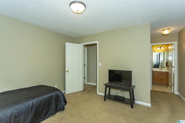 carpeted bedroom with connected bathroom and a textured ceiling