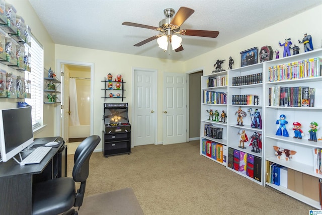 carpeted home office with ceiling fan and a textured ceiling