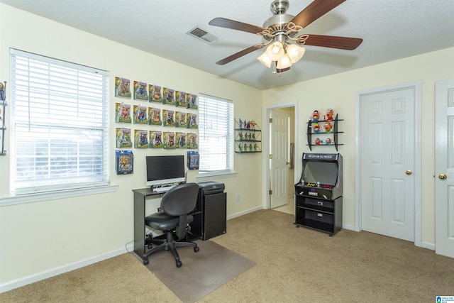 carpeted home office with a textured ceiling and ceiling fan