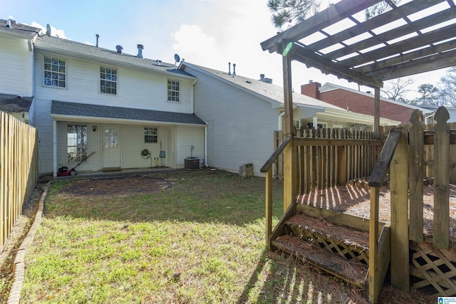 rear view of property featuring a pergola, central AC, and a lawn