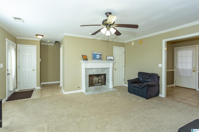 living room featuring light carpet, a fireplace, ceiling fan, and ornamental molding