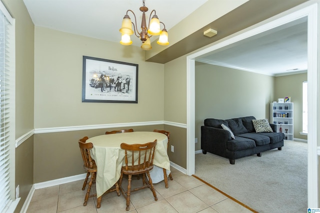 carpeted dining space featuring ornamental molding and a notable chandelier