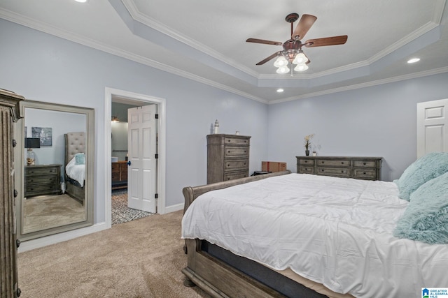 carpeted bedroom with a tray ceiling, ceiling fan, and crown molding