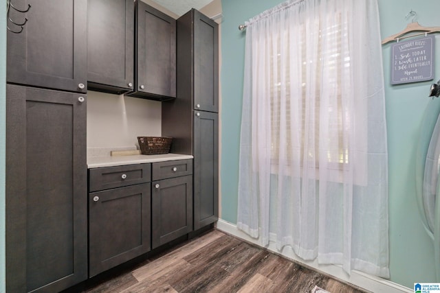 kitchen with dark brown cabinets, dark hardwood / wood-style flooring, and fridge