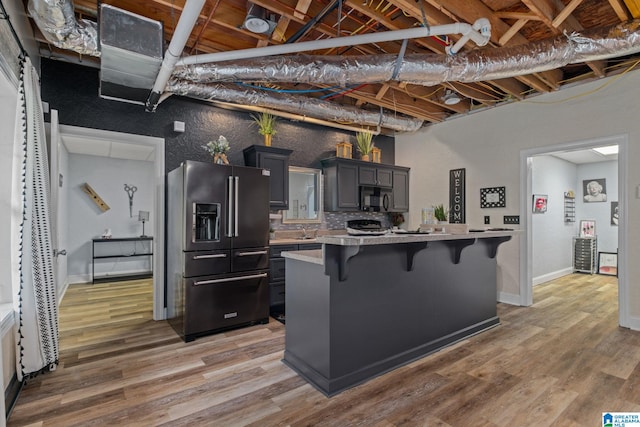 kitchen with a center island, wood-type flooring, a breakfast bar area, and high quality fridge