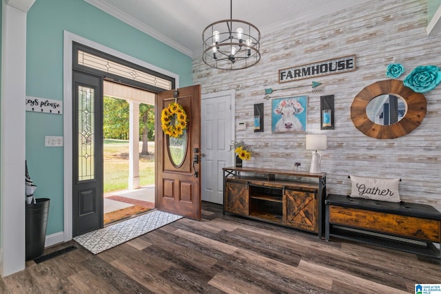 entrance foyer with a chandelier, wooden walls, crown molding, and dark wood-type flooring