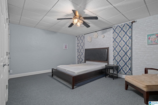 carpeted bedroom featuring ceiling fan and a drop ceiling