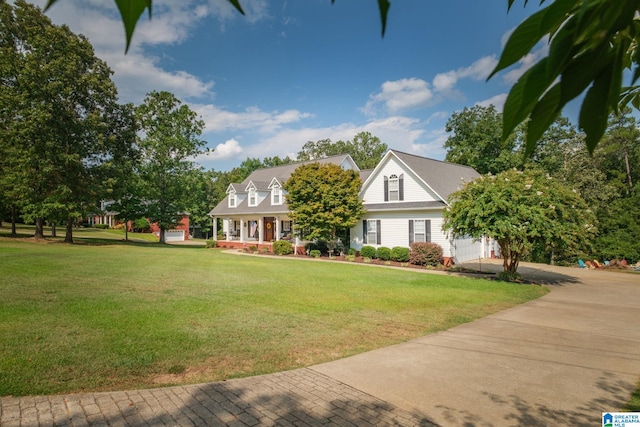 new england style home with a front lawn, a porch, and a garage