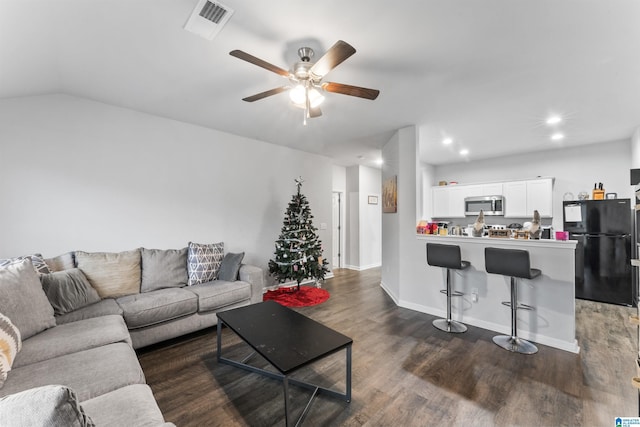 living room with ceiling fan, dark wood-type flooring, and lofted ceiling