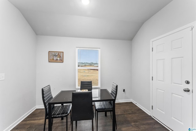 dining space featuring dark hardwood / wood-style flooring and vaulted ceiling