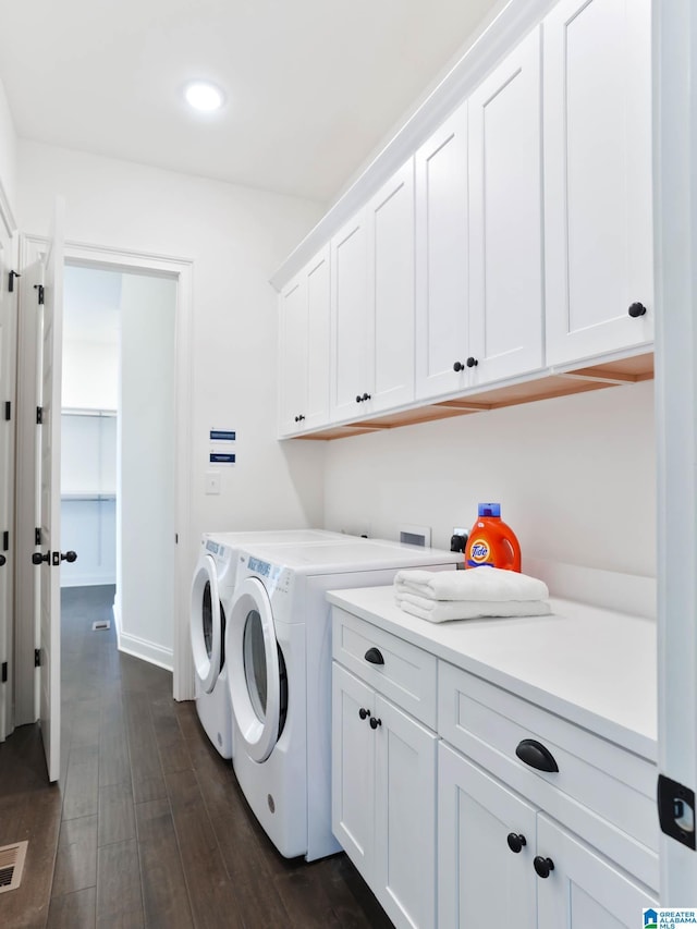 laundry room with cabinets, dark hardwood / wood-style flooring, and washing machine and clothes dryer